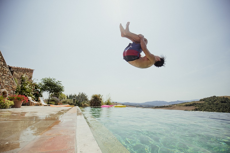 boy backflipping into pool